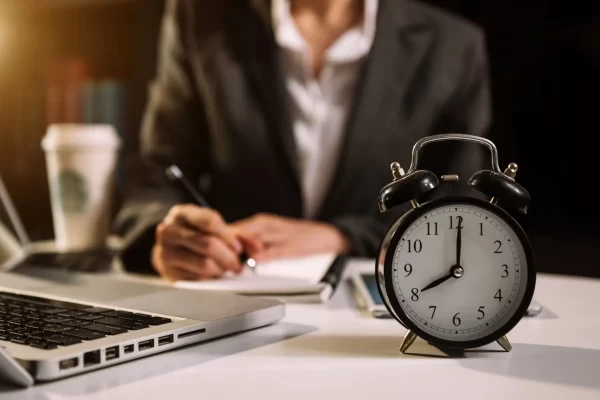 alarm-clock-desk-business-working-modern-office-building-office-night-using-laptop-scaled